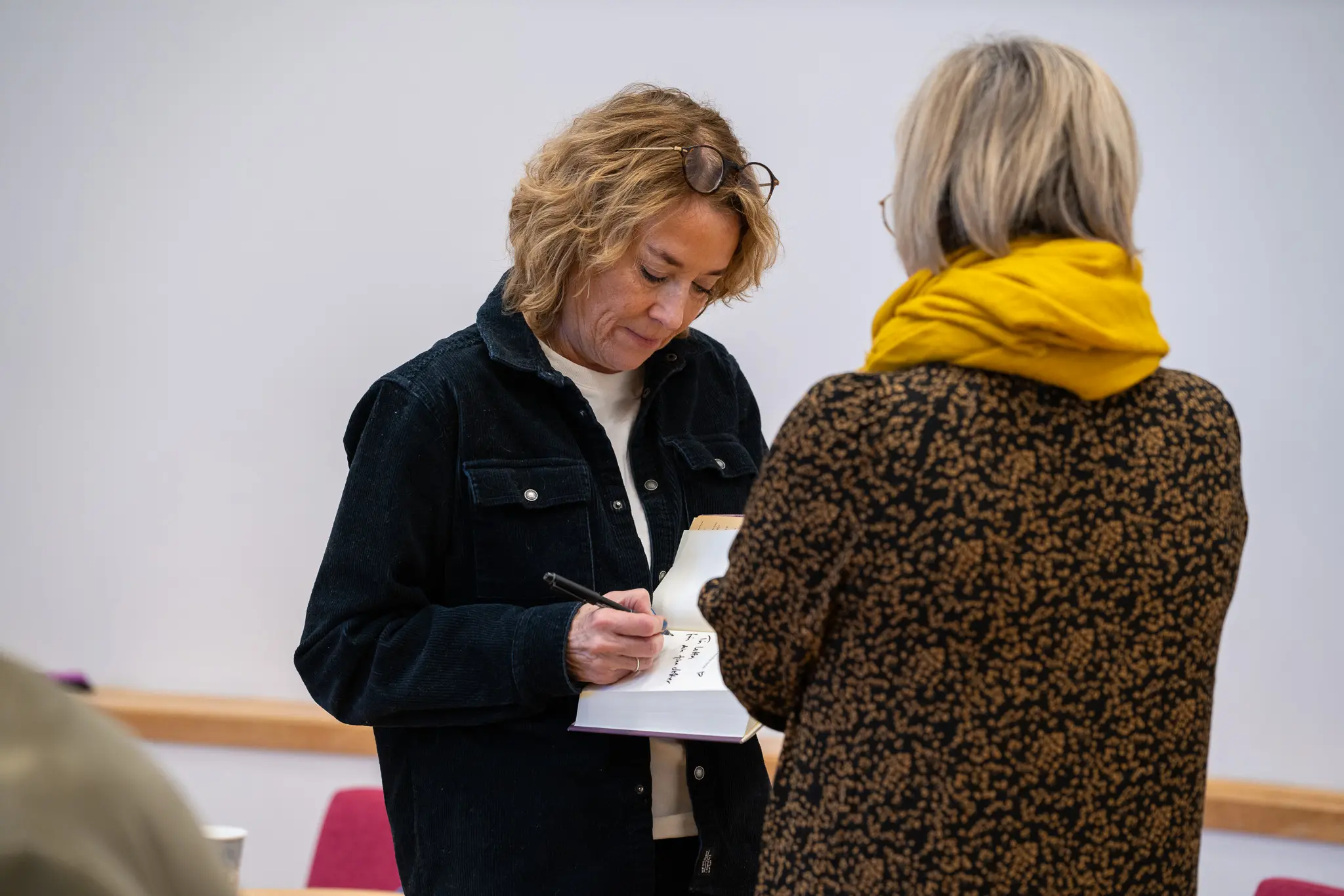 Mian Lodalen signs one of the guests' books.